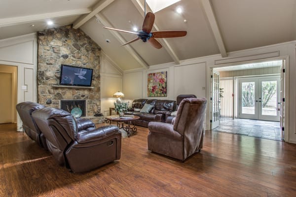 Living room with brown leather recliners and a stone fireplace.