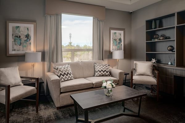 A tranquil living room setup with a sofa, armchairs, and a coffee table, featuring natural light.