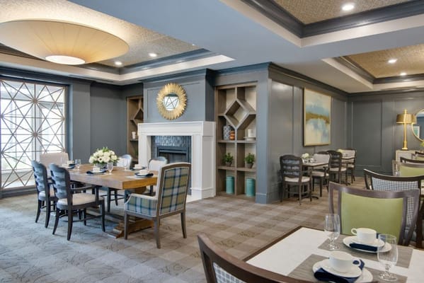 A dining area featuring tables and a decorative fireplace in The Solana East Cobb.