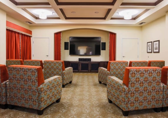 Bright common area with colorful seating and a TV