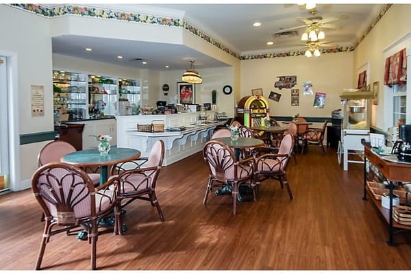Inviting cafe area with tables and chairs, featuring a jukebox and service counter.