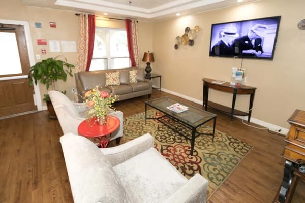 Living room area with seating, a coffee table, and a television.
