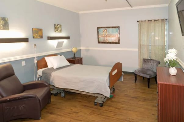 Cozy bedroom with a hospital bed, armchair, and decor