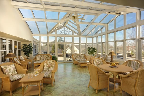 Sunroom with comfortable seating and large windows