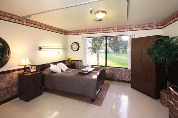 A cozy resident room with a bed and window view