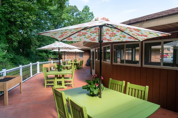 Outdoor seating area with floral umbrellas and greenery