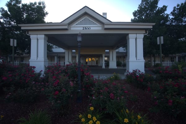 Entrance of Woodland Estates with flower beds and signage