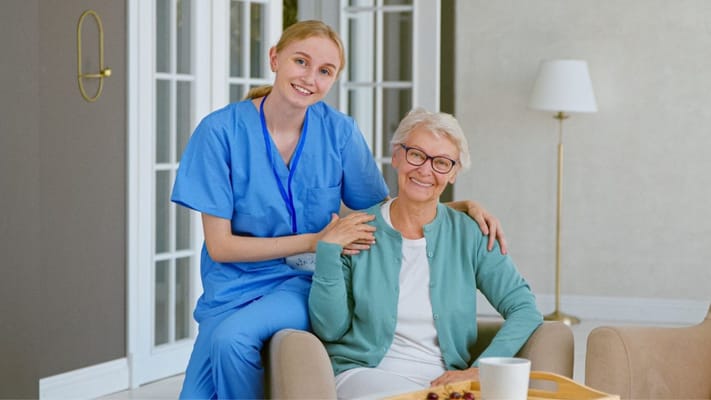 Nurse and resident smiling in a shared lounge area