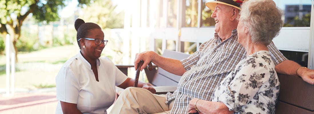 Residents chatting with staff in an outdoor area