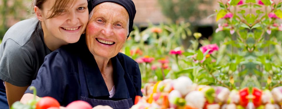 Resident and staff member gardening together in a vibrant garden