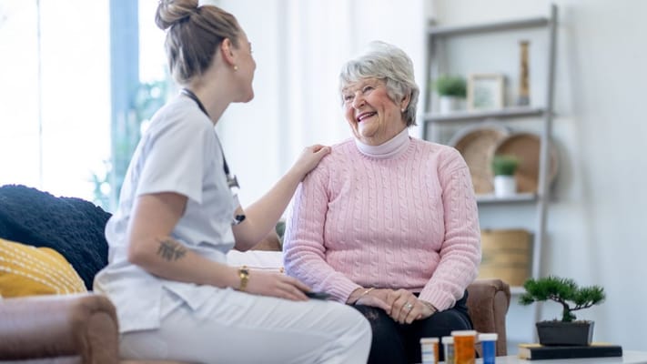 A caregiver chatting with a smiling senior resident