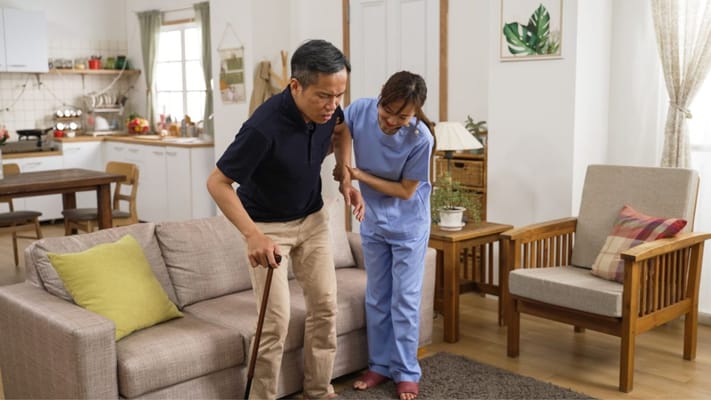 Caregiver assisting a resident in a living room