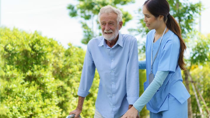Caregiver assisting a senior outdoors