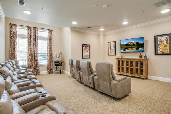 Comfortable common area with reclining seats and a TV