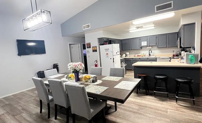 Modern dining area with a large table and kitchen