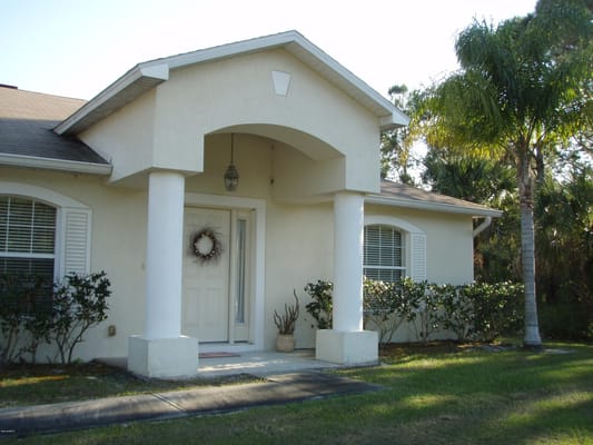 The entrance of A & C Living Faith Home with a welcoming door and landscaping.
