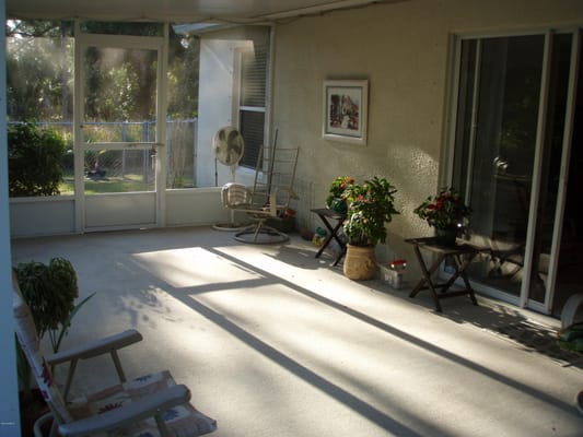 Screened porch with chairs and plants