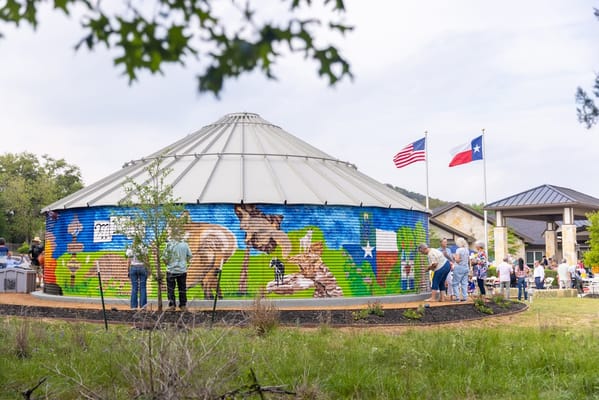 Residents enjoying an outdoor event near a colorful mural