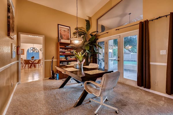 A dining area with a table, chairs, and a view of the outdoors.