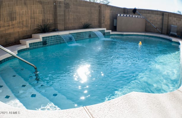 A serene swimming pool with waterfalls at Amiga 3 Assisted Living Home