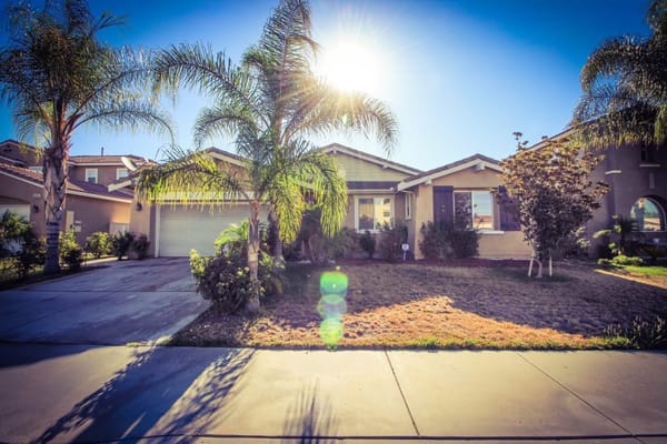 Exterior view of Aqua Bella Residential Care with palm trees.