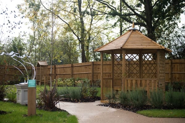 Garden gazebo with paved walkway and greenery