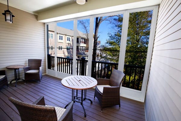 A screened-in outdoor patio with seating