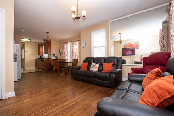 Cozy common area with black sofas and dining table