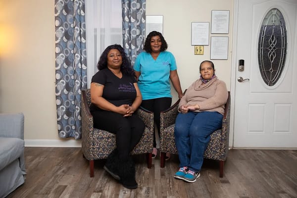 Three individuals seated in a lounge area, smiling.