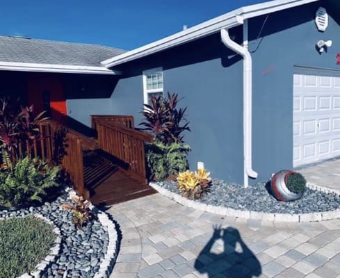 Wooden ramp leading to entrance of assisted living facility with landscaped garden