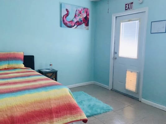 Colorful bedroom with a striped quilt and an elephant painting on the wall