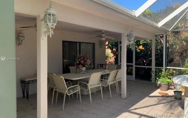 Covered patio with dining furniture and plants