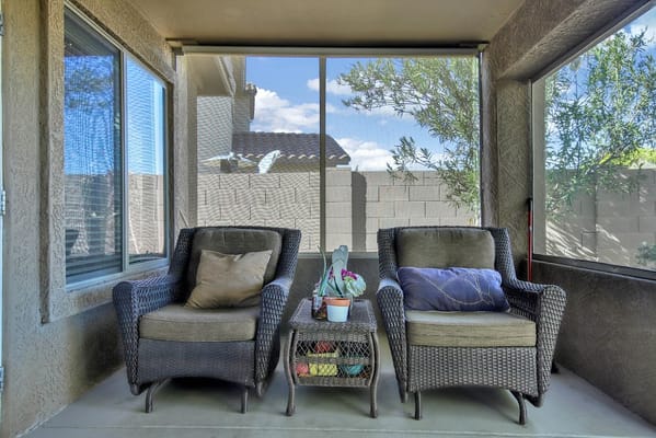Outdoor seating area with shaded chairs and potted plants