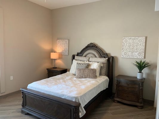 Stylish bedroom with a bed, lamp, and decorative wall art.
