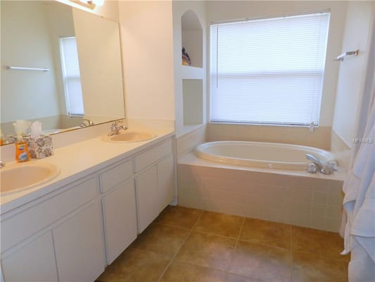 Bright bathroom with double sinks and a soaking tub.