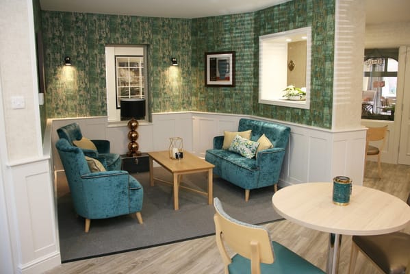 Cozy lounge area with teal chairs and light decor