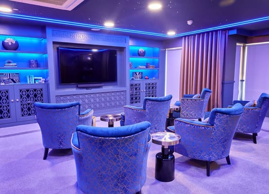 Interior lounge area with blue chairs and ambient lighting