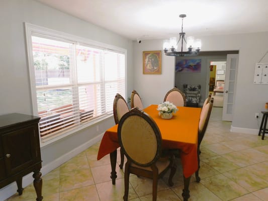 Dining area with a decorative orange tablecloth and chairs
