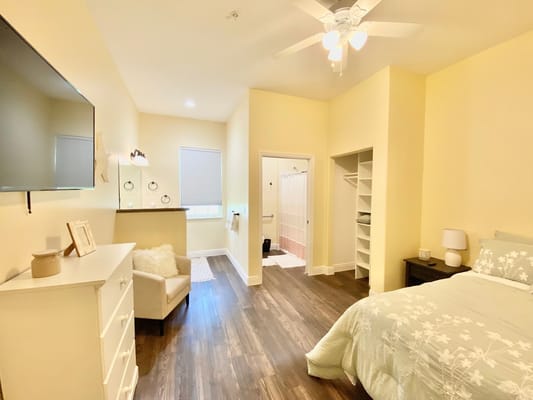 A bright private resident room with a bed and bathroom