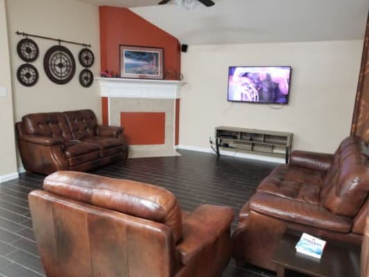 Cozy common area with leather sofas and TV