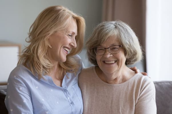 Two smiling women in a cozy living space