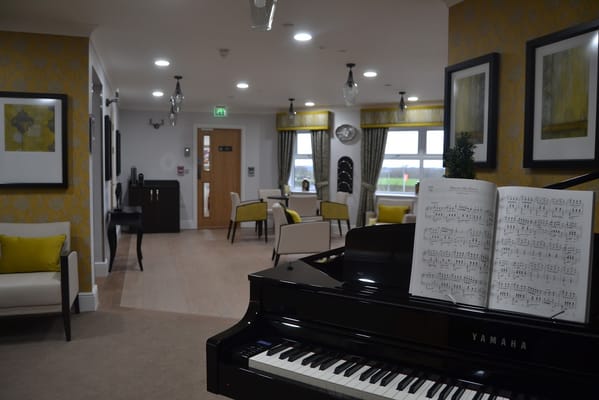 Interior view of a care home common area with a piano