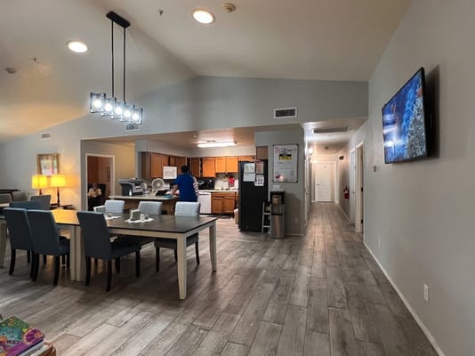 Open kitchen and dining area in senior living facility with residents.