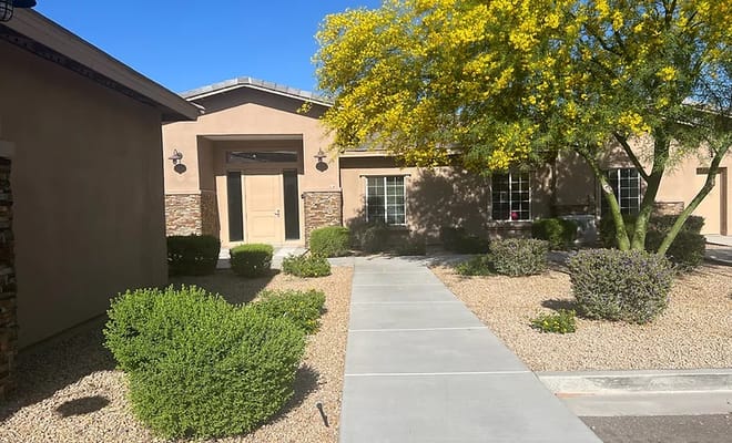 Front entrance of Mayfair Eden Homes with landscaping and pathway.