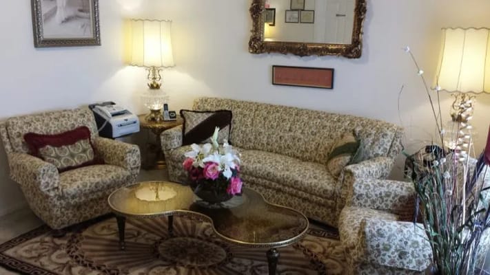 Comfortable living room space with floral furniture and decorative lamp.