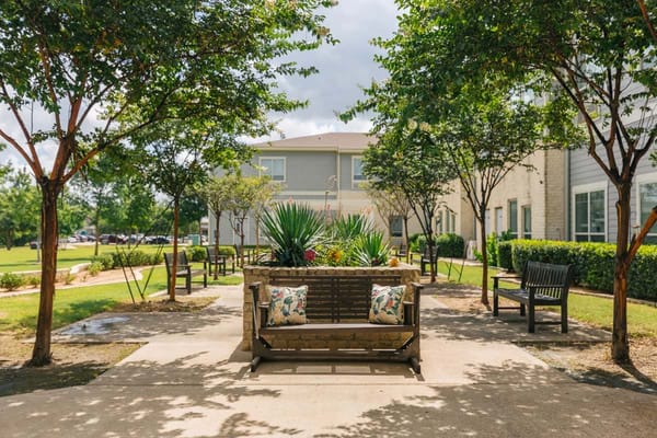 Seating area with benches and greenery at Midtowne Assisted Living