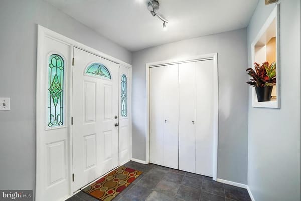 Bright entryway with decorative glass doors and closet