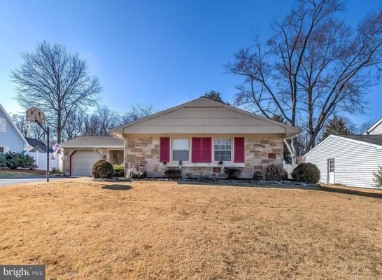 Exterior view of Ovalstone Comfort Home with pink shutters and a basketball hoop.