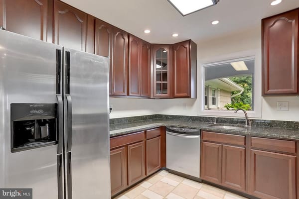 Well-lit kitchen with stainless steel appliances and wooden cabinets