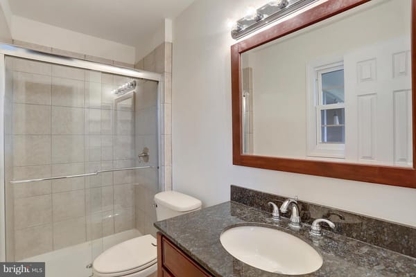 Modern bathroom with glass shower and granite countertop
